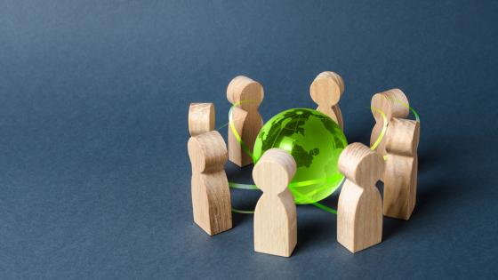 Wooden figures around a globe