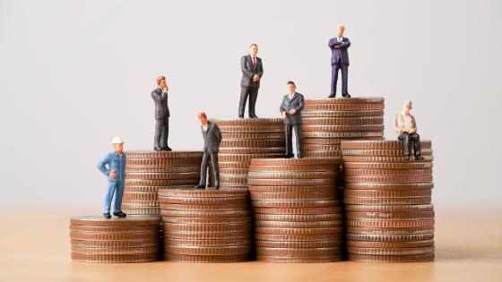 Miniature figures on top of stacks of coins