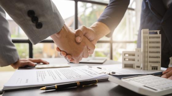 People shaking hands over contract for commercial real estate